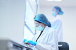 © ultramansk - A researcher performs an aseptic technique inside a Class II biosafety cabinet. The sterile environment is critical for cell culture or virology work in a biotechnology lab.