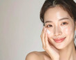 © Hiroshi - Beautiful Asian woman applying face cream with a gentle smile