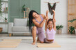 © Pixel-Shot - African-American mother with her teenage daughter practicing yoga at home