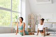 © Pixel-Shot - African-American mother with her teenage daughter practicing yoga on mats at home