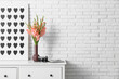 © Pixel-Shot - Picture, photo camera and vase with beautiful gladiolus flowers on chest of drawers in living room, closeup