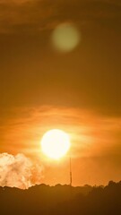 Wall Mural - Timelapse of dramatic sunrise with orange sky in a cloudy day.
