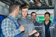 © auremar - mechanic teaching trainees in garage workshop
