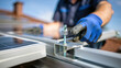 © VITALII - Installer fastening a bolt on a rooftop solar mounting rail.