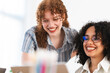 © Studio Marmellata - Two young women share a laugh while working together on a project, their smiles conveying a sense of camaraderie and shared success.