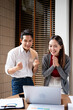 © Fahng - Happy young asian business team celebrating success together. teamwork and business people raise hands for celebration.