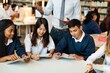 © Rawpixel.com - Diverse group of young students studying together, using tablets in a library. Students collaborating, studying, and using technology. Group of students in library setting. High school education.