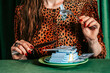 © VISTA by Westend61 - Person in leopard print eating money with fork and knife as satire