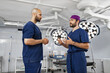 © sofiko14 - Two surgeons are seen in an operating room, engaged in a discussion. The scene is well-lit, highlighting the sterile environment.