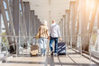 © Anastasiya - Happy mature couple walking hand in hand at airport corridor with suitcases