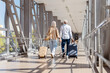 © Anastasiya - Senior man and woman walking through airport with travel bags, holding hands