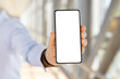 © Anastasiya - Closeup of male hand holding smartphone with blank white screen at airport