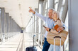 © Anastasiya - Mature couple pointing ahead while holding passports and phone at airport