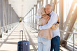 © Anastasiya - Senior couple hugging closely with smiles at airport corridor after arrival