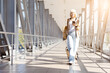 © Anastasiya - Confident senior woman walking with suitcase and smartphone at airport corridor