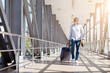 © Anastasiya - Smiling mature man walking through airport corridor with suitcase and passport