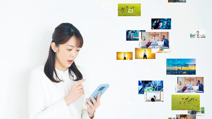 Wall Mural - スマホを見ながら悩む女性と映像コンテンツ