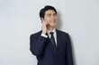 © Yamatatsu - 白背景で通話をするスーツの日本人男性