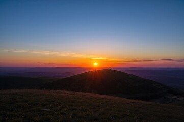 Wall Mural - The golden light of sunset blankets the hills and surrounding scenery.