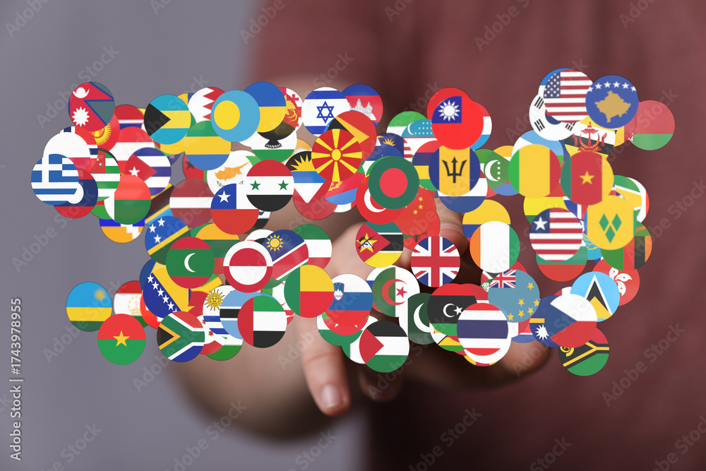 Hand pointing at flags representing countries worldwide, symbolizing ...