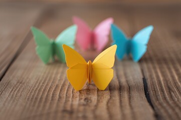 collection of colorful paper origami. yellow butterfly craft on wooden surface with soft focus
