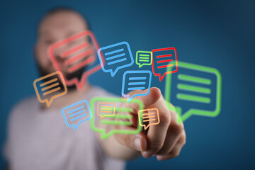 Concept of communication and messaging with a man reaching for neon message bubbles. Illustrates social media and tech.
