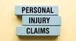 © Drago Designer - Wooden blocks display personal injury claims concept on yellow background