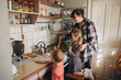 © dsheremeta - Mother preparing food with children in kitchen