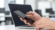 © Octopus16 - Person Using Smartphone in Modern Office Workspace with Laptop and Natural Light