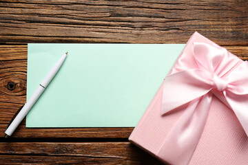 Wall Mural - Blank card, pen and gift box on wooden table, flat lay