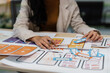 ©  NCST Studio - User experience designer carefully arranging paper wireframes, creating a mobile application layout and digital interface design