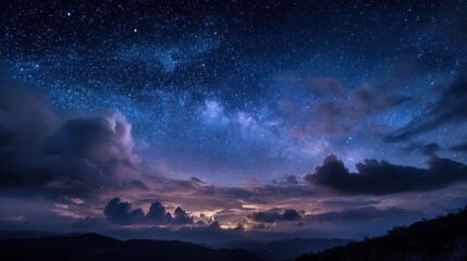 Wall Mural - The sky is dark and cloudy with a few stars visible. The clouds are low and the sky is a deep blue