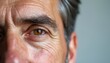 © Viktor - Close up photo of mature man face. Deep wrinkles around eye area highlight the aging process. Detail shot of skin texture. Person looks thoughtful.