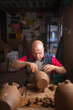 © Lupe Rodriguez/Stocksy - Potter making clay vessels in workshop