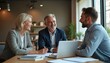 © Viktor - Three business people in office discuss project by laptop. Colleagues collaborate on plan, smiling during meeting. Professionals review documents at desk.