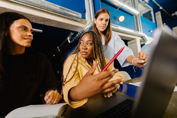 Diverse female entrepreneurs discussing a project  in a boardroom