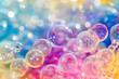 © Duckai - Abstract Background of Colorful Bubbles Rising in a Bright Light Burst with Glossy Reflections and Sparkling Air