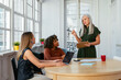 © Peninsula/Stocksy - Diversity professionals women having a presentation in office