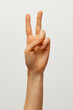 © Maksim - Lady`s hand shows two fingers meaninf 'peace:'  on white background