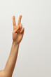 © Maksim - Lady`s hand shows two fingers meaninf 'peace:'  on white background