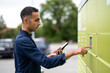 © Sibila and Pavel/Stocksy - Young adult retrieves package from parcel locker, mailbox