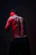 © Javier Díez/Stocksy - Strong male figure in dramatic lighting showcasing athleticism