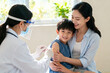 © Gao - Doctor giving child a vaccine with mother present