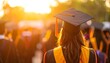 © EBG Stock Studio - Graduada de espaldas con toga y birrete bajo la luz del atardecer durante ceremonia de fin de curso