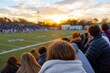 © White Craft  - Exciting High School Football Game Unfolds at Sunset With Cheering Fans