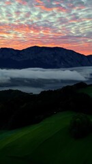 Wall Mural - Vertical View Of A Mountain Silhouettes With Colorful Sunset Sky Covered With Dense Clouds. Aerial Shot