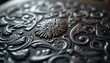 © Vadym - Close up of an ornate metal plate with intricate engraved patterns. The detailed design features swirling floral elements and a central rosette, suggesting fine craftsmanship in a workshop setting.