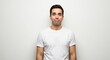 © Adan - Man in white tshirt with a puzzled facial expression against a neutral background
