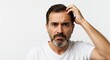 © Adan - Puzzled man with hand on head furrowed brow and beard in front of a plain background