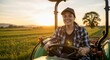 © Vasiliy - Young woman farmer smiling while driving a tractor in a field at sunset. Modern agriculture and rural lifestyle concept